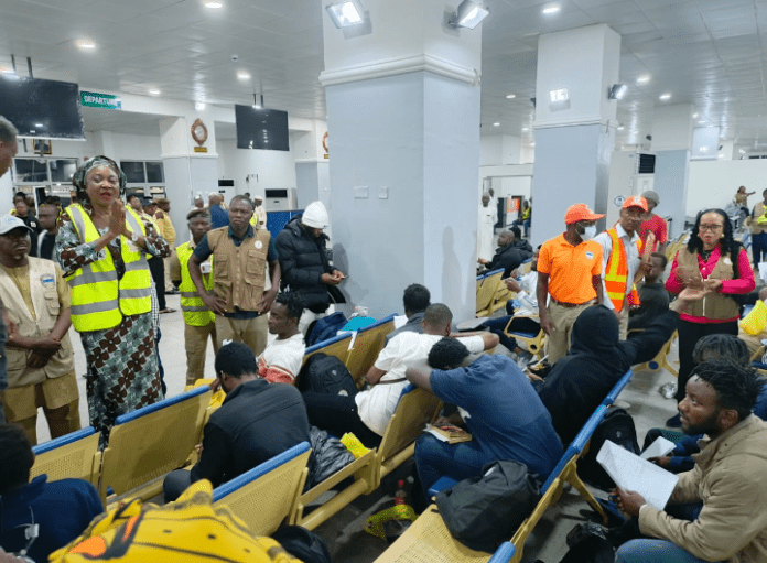 The deportees with officials at the Nnamdi Azikiwe International Airport in Abuja. Photo credit: X/@yabaleftonline.